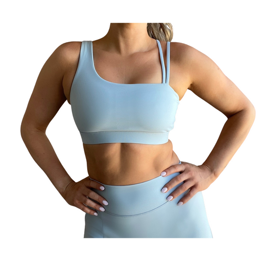 Dusty blue asymmetrical sports bra with one thick strap and two thinner straps